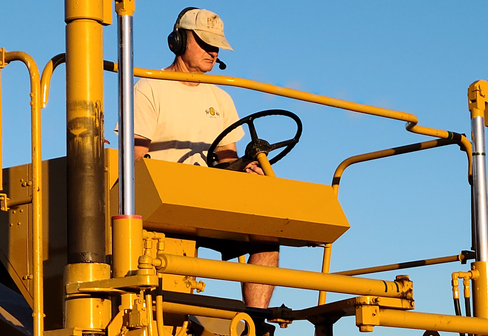Operator driving the restored 1988 French Vectur grape harvester through the vineyard rows